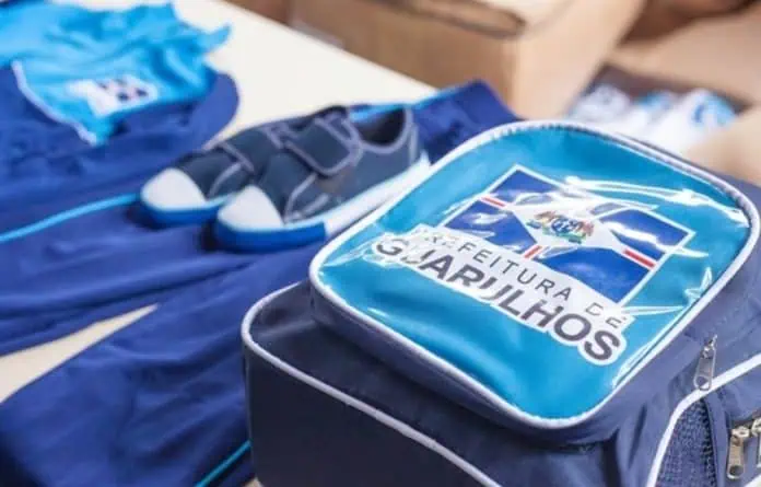 Mães e pais na porta de uma das escolas de Guarulhos conversando sobre o atraso na entrega dos uniformes escolares.