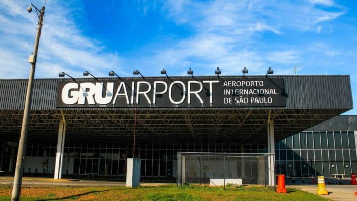 Aeronaves estacionadas nos terminais do Aeroporto de Guarulhos durante o pôr do sol, ilustrando o recorde de voos.