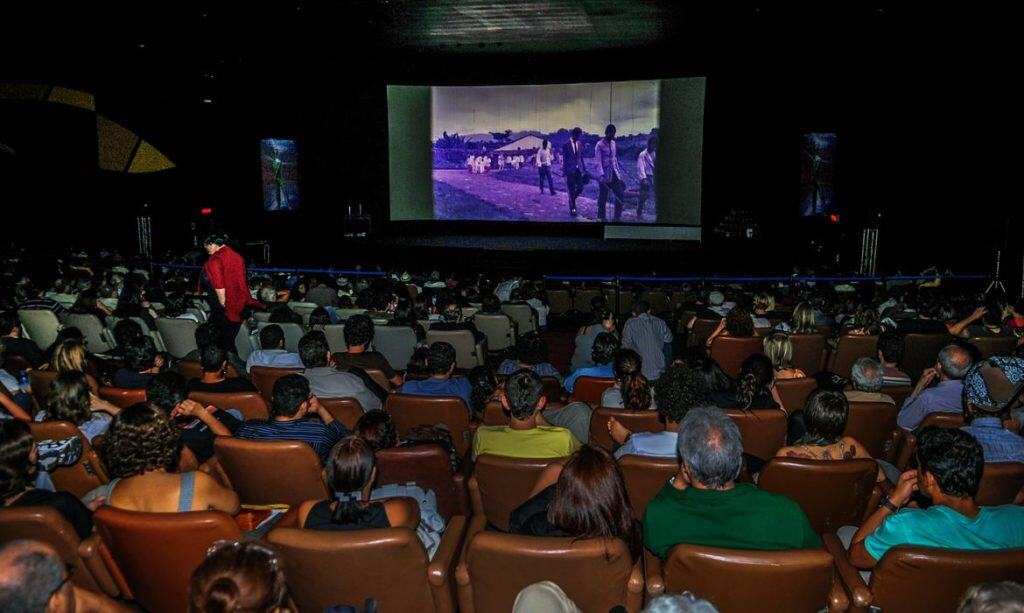 Interior de uma sala de cinema com luzes suavemente acesas, ilustrando como funcionarão os cinemas adaptados para autistas em SP conforme a nova legislação estadual.