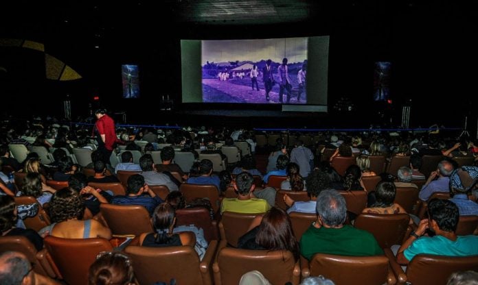 Interior de uma sala de cinema com luzes suavemente acesas, ilustrando como funcionarão os cinemas adaptados para autistas em SP conforme a nova legislação estadual.