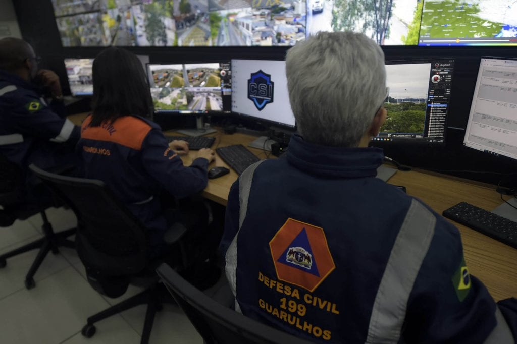 Agente da Defesa Civil inspecionando encosta para garantir os cuidados com o solo em Guarulhos após temporais intensos.