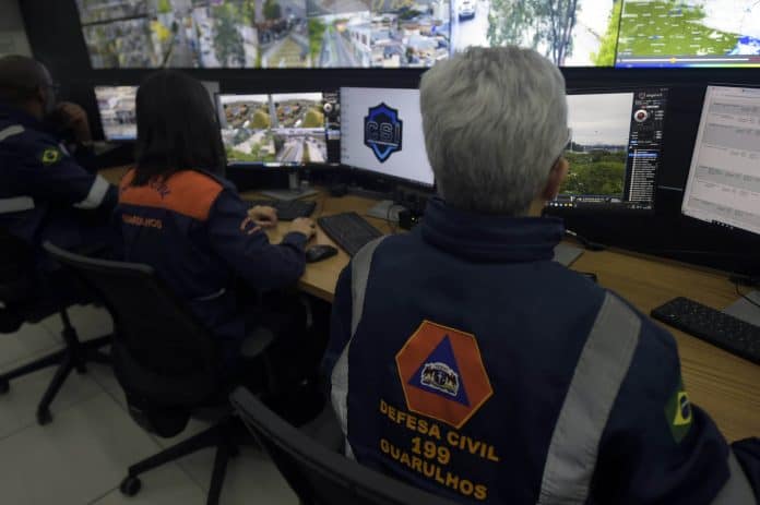 Agente da Defesa Civil inspecionando encosta para garantir os cuidados com o solo em Guarulhos após temporais intensos.