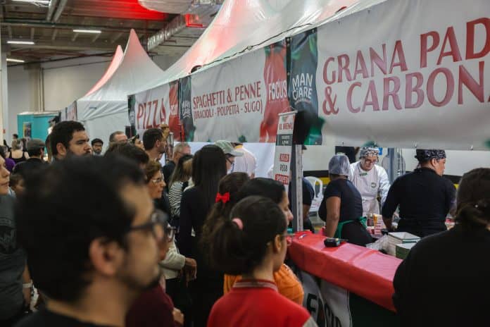 Público celebrando a cultura italiana durante o festival Mangiare Italiafest em Guarulhos no estacionamento do shopping.