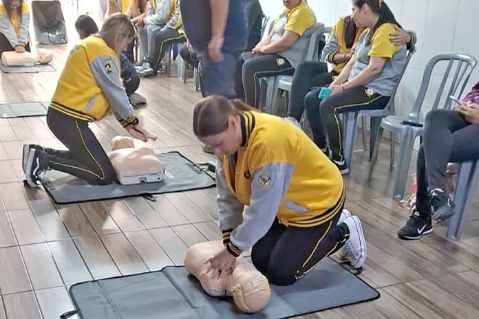 Professores e funcionários de escolas de Guarulhos participam de treinamento prático de primeiros socorros da Lei Lucas, utilizando um manequim de simulação de massagem cardíaca (RCP).