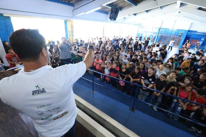 Alunos do projeto Fábrica de Atletas em Guarulhos vestindo os novos uniformes de vôlei e basquete durante cerimônia de entrega oficial.