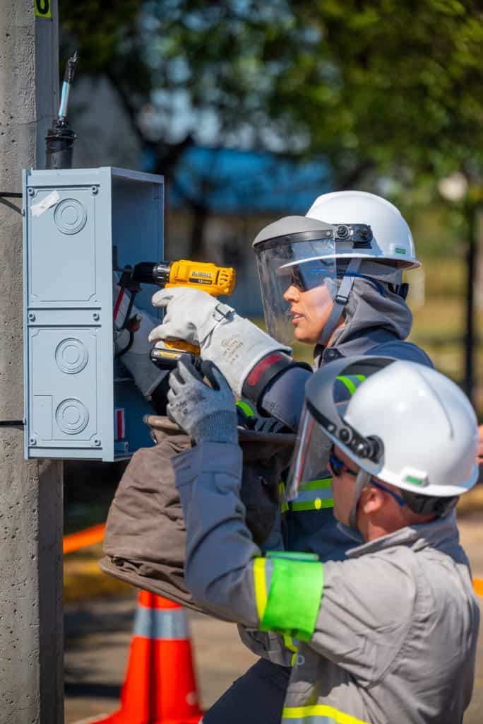 A eletricista Jéssica Batista durante simulação técnica, demonstrando a precisão e o protagonismo das mulheres na energia em rede de distribuição