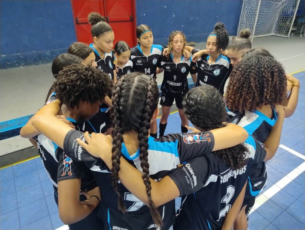 Jovens atletas disputam bola durante treino de futsal feminino em Guarulhos, ilustrando as seletivas para a temporada 2026."