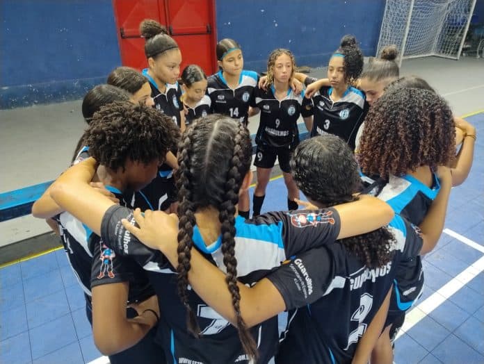 Jovens atletas disputam bola durante treino de futsal feminino em Guarulhos, ilustrando as seletivas para a temporada 2026.