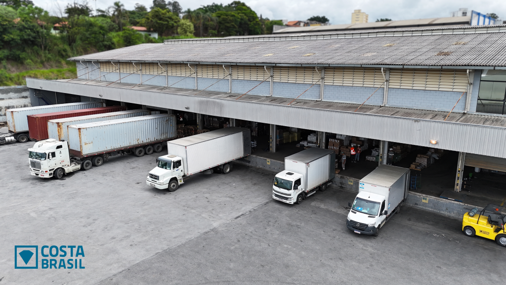 Agentes logísticos movimentando mercadorias em terminal de carga próximo ao Aeroporto, representando as vagas de emprego em Guarulhos na Costa Brasil.